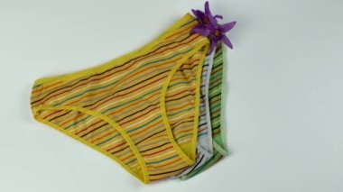 A set of three stylish cotton female briefs on a light background. Colorful erotic womens panties. Womens underwear. The concept of womens wardrobe. Flat lay.