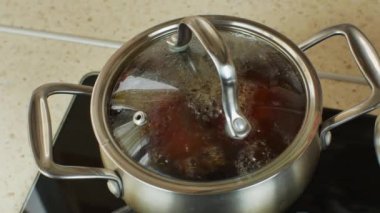 Red beets are boiled in a stainless steel metal pan on a home gas stove. The process of cooking boiled red beets in a pot on a gas stove in a home kitchen. Close-up.