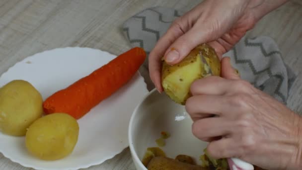 껍질벗기기 여자들은 노란색 껍질을 주방용 접시에 껍질을 감자를 넣는다 건강에 — 비디오