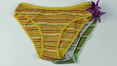 A set of three classic womens cotton panties on a light background close-up. Underwear beauty, comfort, fashion. Creative beauty concept of womens underwear