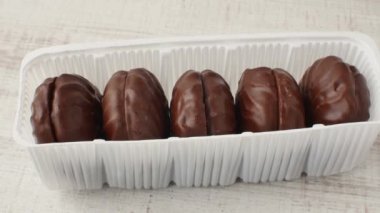 Pakette çikolatalı marşmelov. Çikolata jöleli bir kutu marşmelov masanın üzerinde uzanıyordu. Şekerleme ve şeker taşıyan çocuk konsepti.