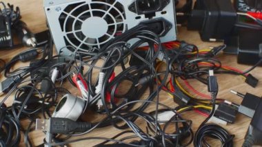 Eski kablolar, bağlantılar, kulaklıklar ve elektronik cihazlar için şarj cihazları eski kablolar, bağlantılar, kulaklıklar ve şarj cihazları ahşap masaya yakın. Elektronik aygıtların eskimesi kavramı.