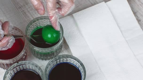 家庭主妇从食物着色的玻璃杯中取出绿色的 蓝色的 紫色的鸡蛋 放在白色餐巾纸上 复活节彩绘不同颜色的鸡蛋的概念 — 图库视频影像