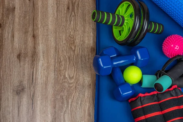 Gym accessories. Close-up of dumbbells for arms and legs, weights for legs, balls for acupuncture points on the body, wheel for training the press and back, a roller for fitness and yoga. Copy space.