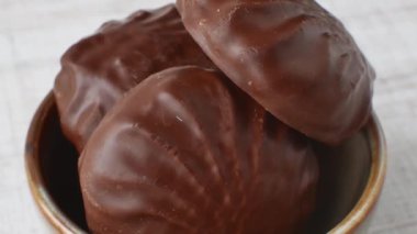 Kahverengi bir kasede çikolatalı şekerlemeler. Çikolata jöleli lokum. Bej bardakta yakın plan. Şekerleme ve şeker taşıyan çocuk konsepti.