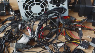 Eski kablolar, bağlantılar, kulaklıklar ve elektronik cihazlar için şarj cihazları eski kablolar, bağlantılar, kulaklıklar ve şarj cihazları ahşap masaya yakın. Elektronik aygıtların eskimesi kavramı.