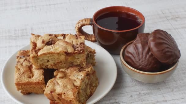 一个有苹果派的盘子 一碗巧克力棉花糖和一杯茶放在一张轻薄的木制桌子上 用甜食喝茶的概念 节日桌上美味佳肴 — 图库视频影像