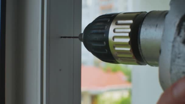 숙련공은 플라스틱 창문에 구멍을 장치를 구멍을 플라스틱 창틀고치기 에서의 — 비디오