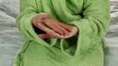 Bir kadın ellerini kremle yağlar. El masajı yapıyorum. Kadınların elleri sağlık hizmetleri. Evde spa tedavisi. Kadın vücut bakımı kavramı. Nemlendirici el kremi