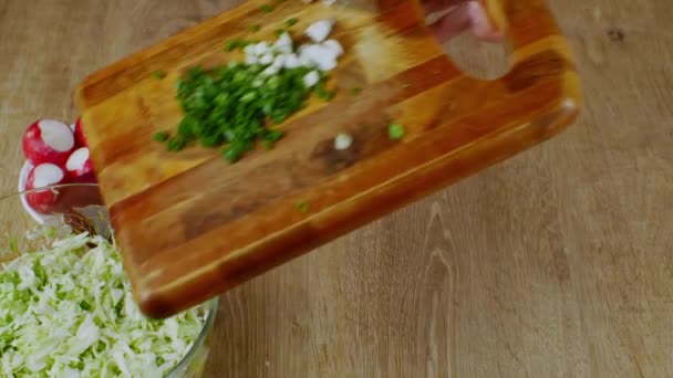Der Koch Legt Gehackte Grüne Zwiebeln Von Einem Holzschneidebrett Eine — Stockvideo