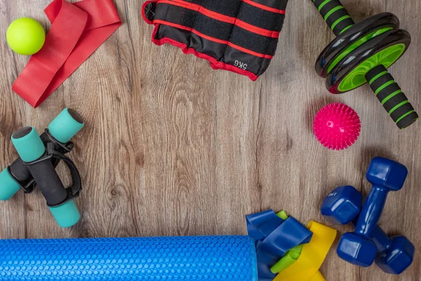 Spor ve beden eğitimi için bir takım ekipman. Dambıllar, bacak ağırlıkları, fitness silindiri, elastik bantlar, dikenli ve pürüzsüz akupunktur topları, karın kasları ve sırt silindiri. Sağlık ve uzun yaşam kavramı.