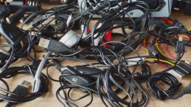Eski kablolar, bağlantılar, kulaklıklar ve elektronik cihazlar için şarj cihazları eski kablolar, bağlantılar, kulaklıklar ve şarj cihazları ahşap masaya yakın. Elektronik aygıtların eskimesi kavramı.
