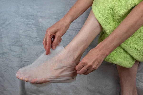 여자들은 화장용 일회용 양말을 사용하여 피부에 급한다 발바닥을 회유하는 발뒤꿈치를 — 스톡 사진