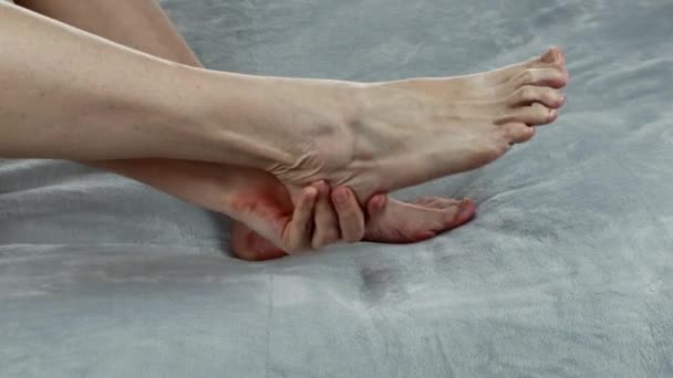 女性は足をマッサージし クリームで足を潤します 足のマッサージを活性化します 女性の足の健康管理 自宅でスパトリートメント 女性のボディケアの概念 足のクリームの保湿 — ストック動画
