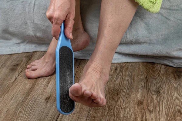 투구풍뎅이로 발뒤꿈치를 문지르고 있습니다 암컷은 물레를 사용하여 깨끗하게 발뒤꿈치의 여성의 — 스톡 사진