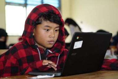 Editorial. Bawang, Jawa Tengah, Indonesia - October 19 2022. Indonesian elementary school students study online using chrome laptops