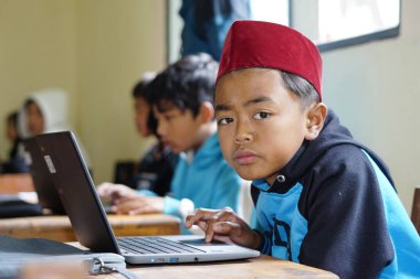 Editorial. Bawang, Jawa Tengah, Indonesia - October 19 2022. Indonesian elementary school students study online using chrome laptops