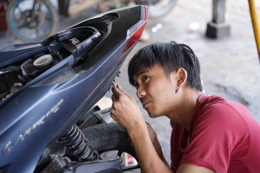 Yazı işleri. Reban, Jawa Tengah, Endonezya - 3 Aralık 2022. Motosiklet tamir eden bir tamirci