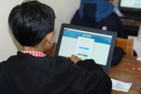 Yazı işleri. Bawang, Jawa Tengah, Endonezya - 19 Ekim 2022. Endonezyalı ilkokul öğrencileri krom dizüstü bilgisayarlar kullanarak online öğrenim görürler.