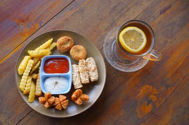 Kızarmış sosisli patates kızartması, nugget, sos ve mayonez.