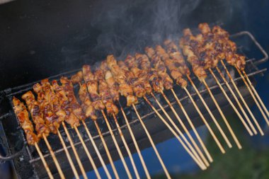 Kömür mangalında ızgara yapan tavuk buğulama şişleri ve sokak yemeklerinde dumanlar yükseliyor. Endonezya gıda kavramı