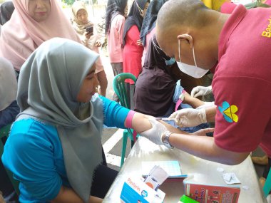 Batang, Jawa Tengah, Endonezya - Ekim 04 2024. Bir klinik laboratuvarında kolesterol ve trigliserit seviyelerini ölçmek için lipid profil inceleme prosedürü. Tıbbi tanı konsepti