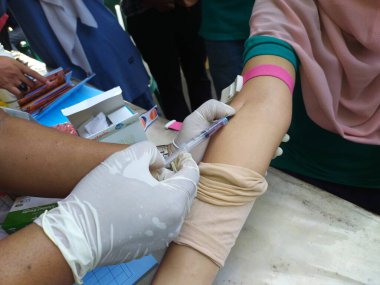 Batang, Jawa Tengah, Endonezya - Ekim 04 2024. Bir klinik laboratuvarında kolesterol ve trigliserit seviyelerini ölçmek için lipid profil inceleme prosedürü. Tıbbi tanı konsepti