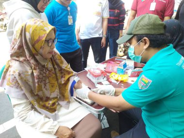 Batang, Jawa Tengah, Endonezya - Ekim 04 2024. Bir klinik laboratuvarında kolesterol ve trigliserit seviyelerini ölçmek için lipid profil inceleme prosedürü. Tıbbi tanı konsepti