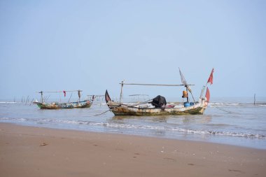 Kuripan, Subah, Batang, Jawa Tengah, Endonezya - 5 Ekim 2024 Geleneksel balıkçı tekneleri gün batımında bir sahilin yakınında sığ sularda demirlediler.