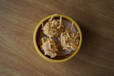 Tahta bir masada, bambu buharlı sepetin içinde üç altın sarısı kızarmış hamur köftesi. Dim Sum kavramı.