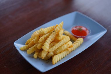 Mavi tabakta domates soslu kızarmış patates kızartması.