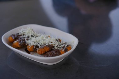 Lezzetli Endonezya sokak yemekleri tatlı Pisang Goreng, bol çikolata soslu ve tuzlu peynirli kızarmış muzlar. Tatlı çerez konsepti
