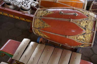 Gamelan müziğinde ritmi sağlamak için kullanılan süslü, kırmızımsı kahverengi ahşap oymalı bir vücudun yer aldığı geleneksel bir Java Kendang davulunun ayrıntılı bir yakın çekimi. Endonezya kültür mirası konsepti