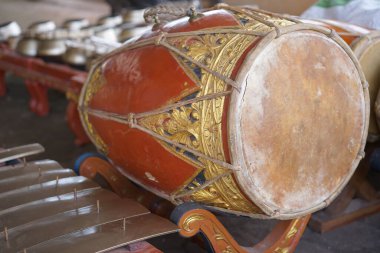 Gamelan müziğinde ritmi sağlamak için kullanılan süslü, kırmızımsı kahverengi ahşap oymalı bir vücudun yer aldığı geleneksel bir Java Kendang davulunun ayrıntılı bir yakın çekimi. Endonezya kültür mirası konsepti