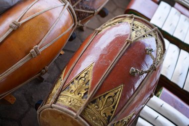 Gamelan müziğinde ritmi sağlamak için kullanılan süslü, kırmızımsı kahverengi ahşap oymalı bir vücudun yer aldığı geleneksel bir Java Kendang davulunun ayrıntılı bir yakın çekimi. Endonezya kültür mirası konsepti