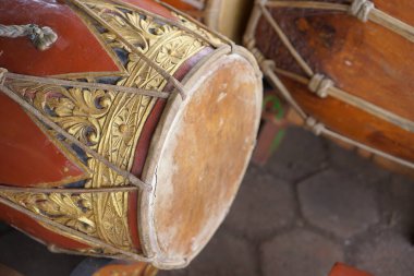Gamelan müziğinde ritmi sağlamak için kullanılan süslü, kırmızımsı kahverengi ahşap oymalı bir vücudun yer aldığı geleneksel bir Java Kendang davulunun ayrıntılı bir yakın çekimi. Endonezya kültür mirası konsepti