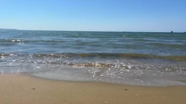 Küçük, sürekli dalgaların sakin bir şekilde sahile vurması. Huzurlu ve doğa temalı projeler için mükemmel..