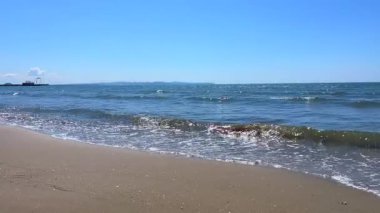 Güçlü okyanus dalgaları kıyı şeridi boyunca enerji ve hareketi vurguluyor..