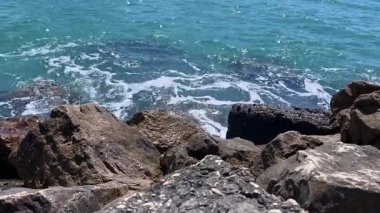 Okyanus dalgalarının geniş açılı görüntüsü engebeli kıyı şeridindeki kayalara çarpıyor..