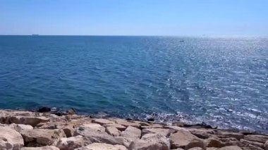 Kıyı şeridi boyunca taşlarla panoramik okyanus manzarası sahilin ve suyun doğal güzelliklerini yakalıyor..