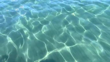 Açık mavi denizdeki güneş ışığı, suyun yüzeyinde göz kamaştırıcı bir etki yaratıyor..