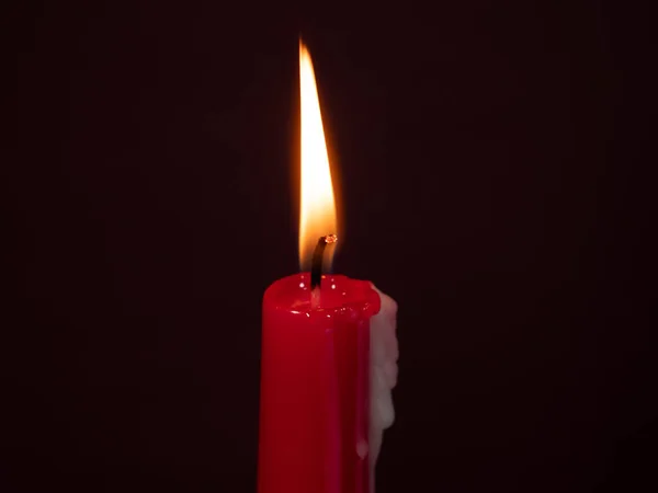 Burning red candles. Burning candles on a dark background. Close-up.