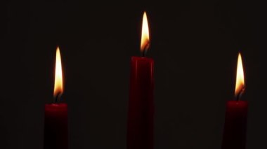 Kırmızı mumlar yanıyor. Karanlık bir arkaplanda mum yakmak.