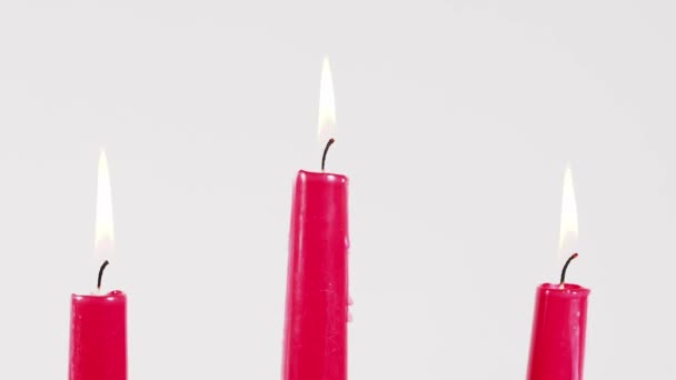 在白色的背景上燃着红色的蜡烛 点着蜡烛 — 图库视频影像