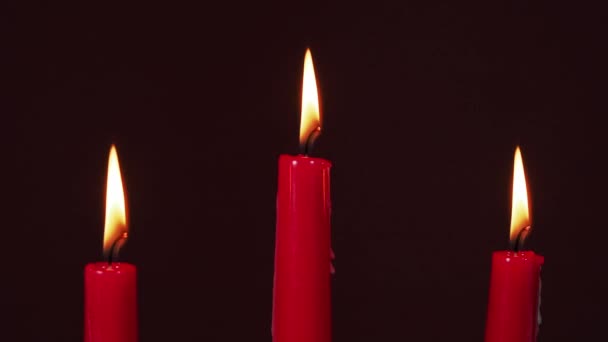 燃烧着红色的蜡烛 在黑暗的背景上燃着蜡烛 — 图库视频影像