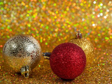 Altın bir arka planda Noel topları. Güzel bokeh 'li Noel süsü. Çok renkli toplar.
