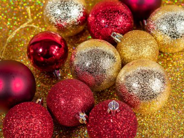 Altın bir arka planda Noel topları. Güzel bokeh 'li Noel süsü. Çok renkli toplar.