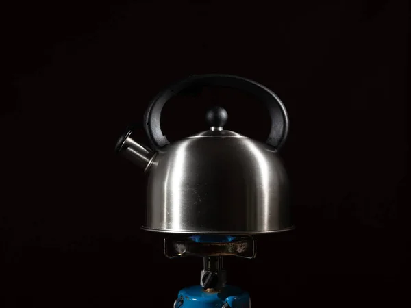 把水壶放在煤气炉上 黑暗背景下的燃烧器上的水壶 — 图库照片