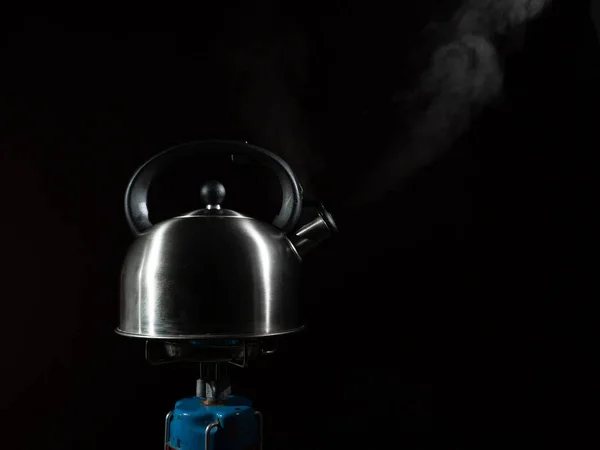 把水壶放在煤气炉上 黑暗背景下的燃烧器上的水壶 — 图库照片