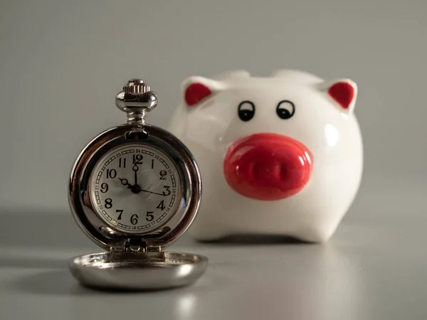 灰色背景的旧怀表和小猪银行时间的概念就是金钱 — 图库照片#
